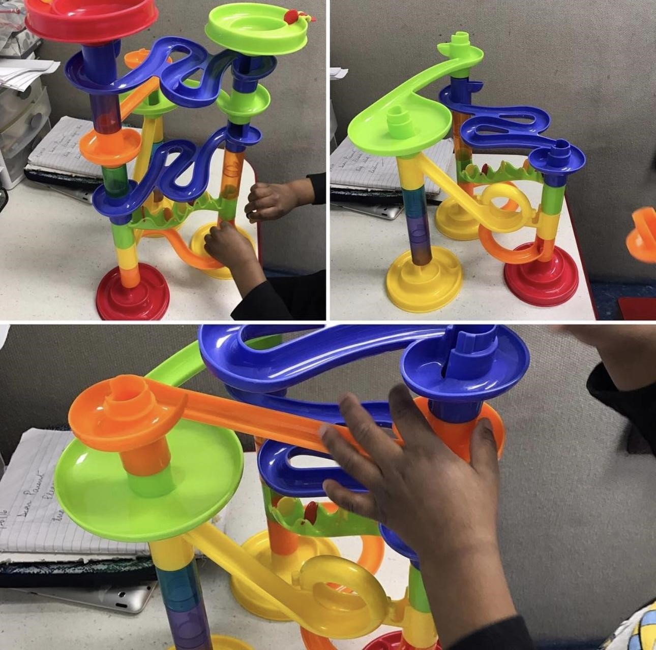 Children playing with a colorful marble run toy set on a table.